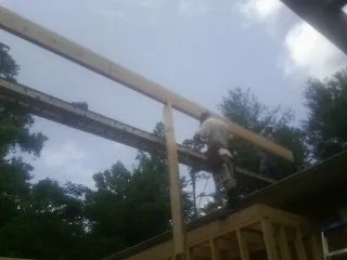 Carpenter setting a ridge beam over a new addition frame — Ice Dam Removal by Roofing Brothers in Newnan