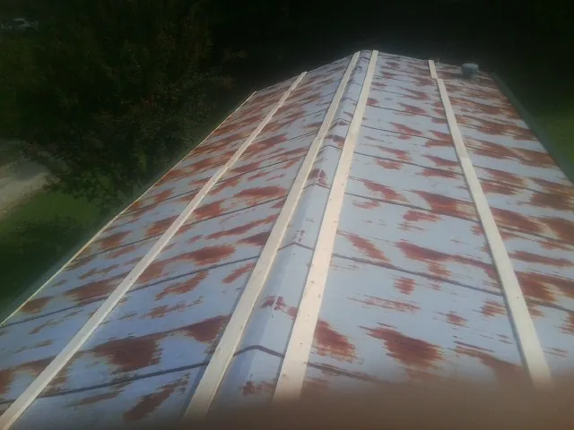 Rusted metal roof panels with new wood purlins before replacement — Storm Damage Roof Repair in Newnan by Roofing Brothers