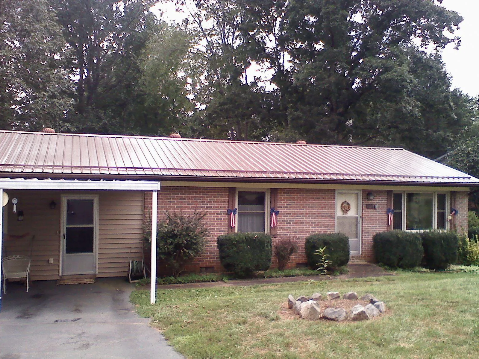 Bronze metal roof and carport on a brick ranch home — Roof Repair work by our crew in Newnan