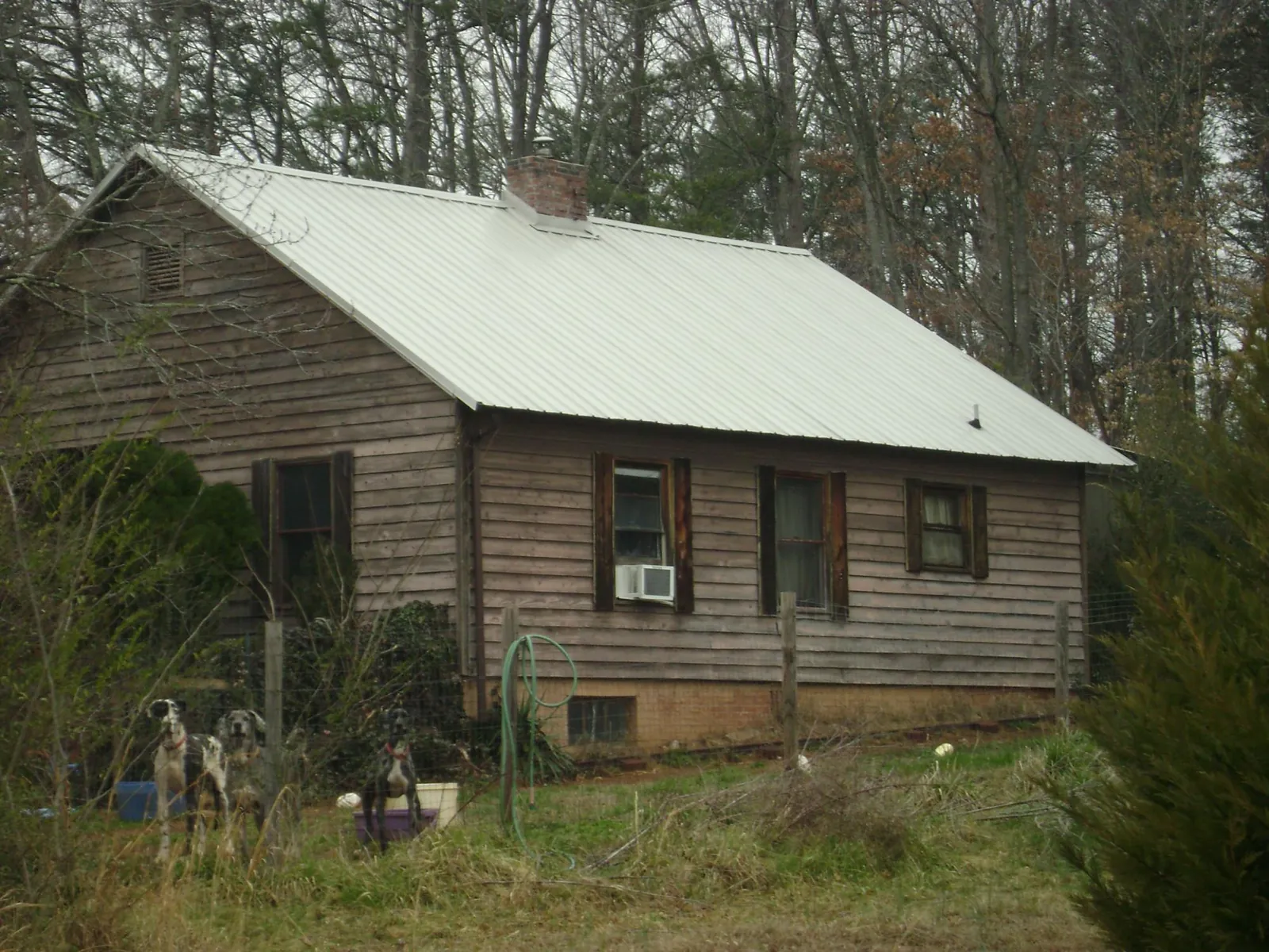 White metal roof on an old wood sided farmhouse, from a Metal Roof Installation job in Newnan